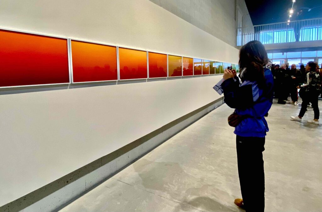 Suivre le fleuve et ses affluents : depuis plusieurs éditions, le FAB invite le public à l’exploration sensible des espaces naturels liés à l’eau (voir l’article). Cette année, une carte blanche a été proposée à Nicolas Floc’h, un photographe unique dont le travail s'inscrit dans une démarche éco-responsable et de sensibilisation. Explorateur des fonds marins, il s’intéresse aux tonalités de l’eau depuis longtemps. Pas uniquement celle de la surface, car il procède à un minutieux relevé photographique jusque dans les profondeurs. Après les océans, il décrypte à présent un fleuve, et par n’importe lequel, puisqu’il s’agit de celui le plus chargé en sédiments de France. Or, cette production photographique documentaire, fruit d’un travail avec les équipes du festival, aboutit à un résultat plastique inattendu. Séries de monochromes Malgré les apparences de nuancier, la fresque que nous découvrons n’est pas ordonnée selon son aspect pictural. Elle respecte la géographie, offrant en quelque sorte une vue en coupe du fleuve. Le végétal et le minéral ne sont pas représentés de façon réaliste, ni dans un style impressionniste, mais abstrait. Sans effet ostentatoire de brillance ou de matière, on passe brusquement de couleurs très chaudes (orange et rouge) à une zone verte. La rupture est nette. À quoi ce rendu inattendu correspond-il ? PH Marron, ocre, bronze, fauve… La tonalité varie en fonction du territoire et de l’environnement, du relief, de l’occupation et de la nature des sols, du type de végétation. La saturation des pigments augmente avec l’accumulation. Certains éléments sont liés aux saisons. Ainsi, crues et intempéries peuvent-elles modifier la couleur. La manière dont le fleuve interagit avec l’océan peut aussi avoir une influence. Le net changement chromatique correspond à l’interaction avec l’Atlantique, et la densité du phytoplancton. Ligne de vie entre nature et humains, terre et océan. Immersions La série d’images photos prises du fleuve découle d’un long processus créatif et relève d’un protocole. Les images sont captées avec un objectif grand angle, pour un cadrage frontal. Les prises de vues sont réalisées à différentes profondeurs dans la colonne d’eau, plus précisément la zone éclairée naturellement. Si Nicolas Floc’h peut aller jusqu’à 100 m dans l’océan, les 5 m de la Garonne ont suffi pour saisir les variations recherchées. La moitié des images est noire et chaque colonne correspond à un espace de 2 à 3 km, dans un parcours totalisant 130 km jusqu’à l’Estuaire de la Gironde. « Chaque fleuve a sa signature » Nourri de travaux de terrain, donc, ainsi que de lectures et d’échanges avec des spécialistes, le projet est passionnant. L’artiste révèle des variations de couleurs insoupçonnées, quasi invisibles à l’œil nu, qui traduisent en substance les caractéristiques du milieu. De plus, cette écriture du vivant, du minéral, des sols, de l'espace, du climat, s’inscrit dans une démarche au long cours visant à étudier des écosystèmes menacés. Formidable adéquation entre le fond et la forme ! D’autres grilles seront effectivement exposées jusqu’en 2027, puisqu’il s’agit d’explorer tout le territoire en amont du bassin. D’ici là, comment les changements globaux imprègneront-ils cette œuvre en devenir ? Cette expérience chromatique évolutive est donc à suivre. De près. Nicolas Le Floc’h redéfinit le paysage photographié de façon très originale. Avant tout artistique, le projet découle aussi d’un intérêt pour des installations immersives, comme celles de James Turrell. Il trouve toutefois sa source dans l’histoire de l’art, notamment les peintures de paysage de William Turner. Pas seulement Klein ou Rodtchenko. À la fois des témoins historiques et des muses artistiques, les cours d’eau reflètent la relation complexe entre les sociétés humaines et leur environnement naturel. Garonne Océan en est l’éclatante illustration. © Sarah Meneghello